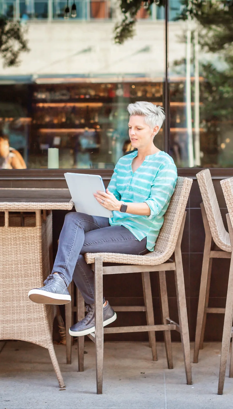 Debbie enjoying a quiet moment with a tablet at an outdoor café